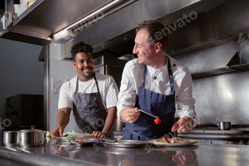 Preview: Positive diverse colleagues preparing haute cuisine dish