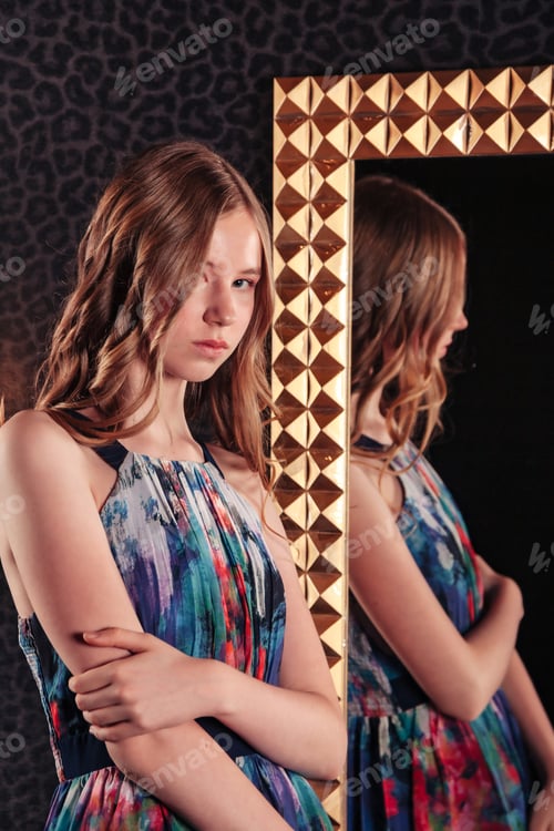 Preview: Portrait of pretty cute teenager girl in an elegant dress at mirror