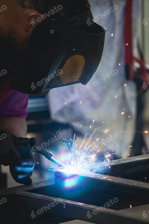 Preview: Industry worker welding iron pieces at work