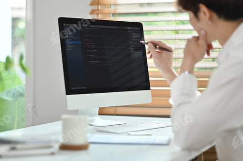 Preview: Side view of professional software developer working with coded data in bright modern office.