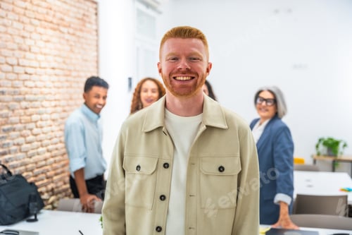 Preview: Redhead man smiling with diverse office team