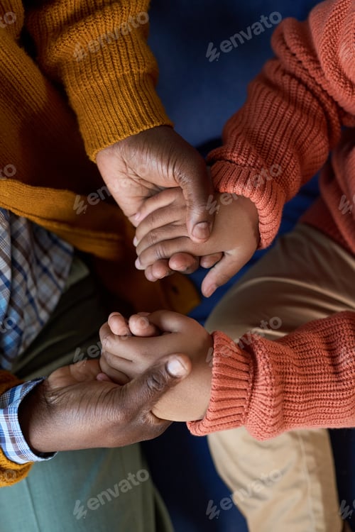 Preview: Mature Black Man Holding Hands with Black Child Offering Comfort