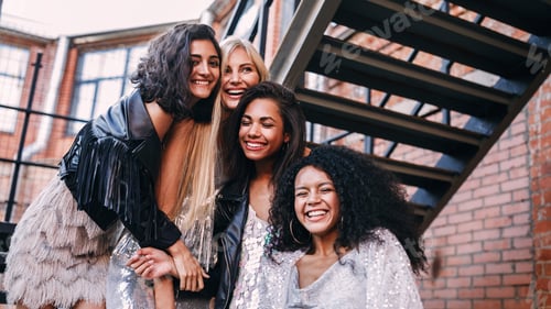 Preview: Multi-ethnic group of female friends laughing outdoors standing on the staircase
