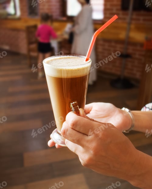 Preview: cup of latte coffee in the hands of the waiter close-up, cappuccino