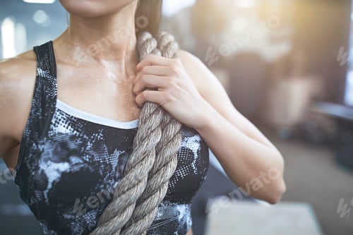 Preview: Young woman exercises in gym healthy lifestyle standing with rope