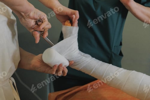 Preview: Medical professional bandaging patient leg in clinic