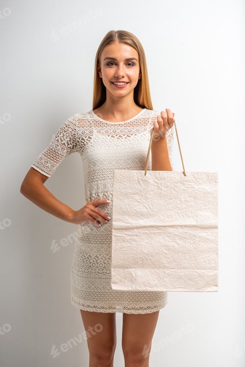 Preview: Smiling Woman in White Dress Holding Shopping Bag
