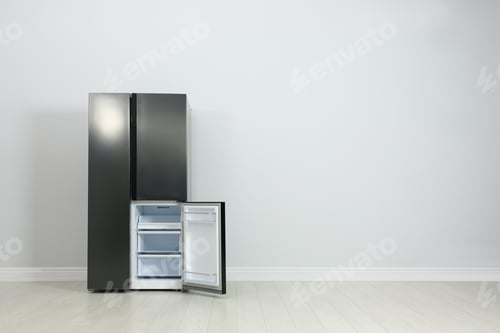 Preview: Modern refrigerator near light grey wall. space for text
