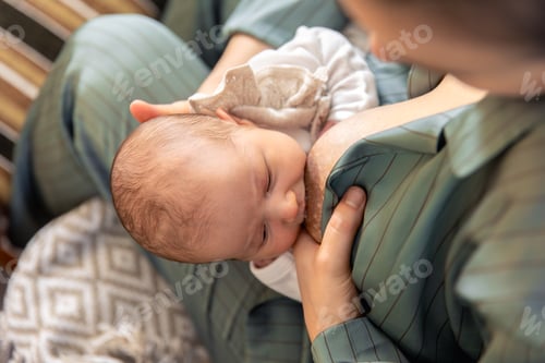 Preview: A mother breastfeeds a newborn baby. Motherhood child care concept.