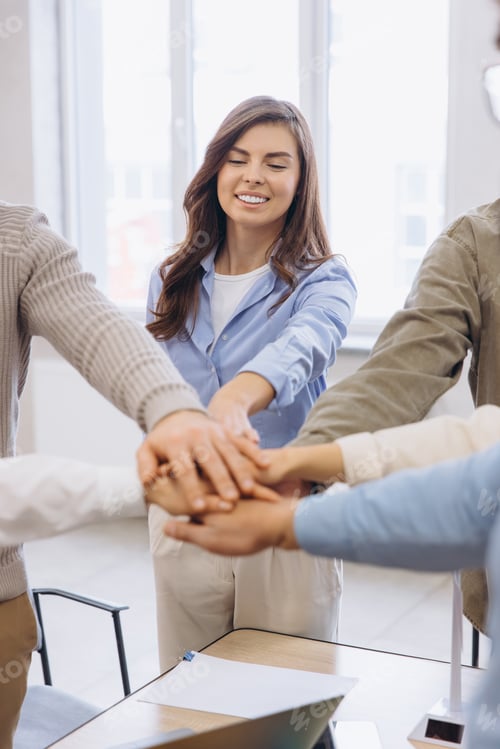 Preview: Business people stacking hands showing teamwork