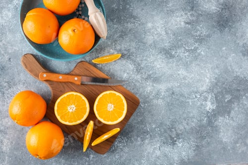 Preview: Sliced orange fruits with whole oranges on a wooden board