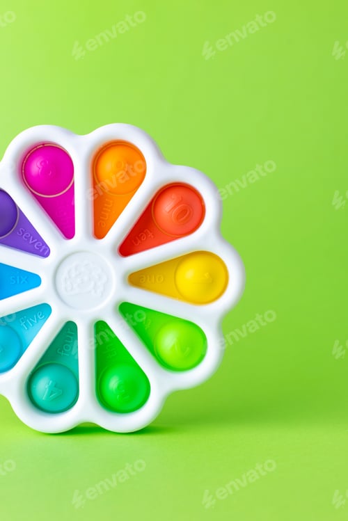 Preview: Presses with a finger anti-stress toy pop it on green background. Colorful silicone poppit