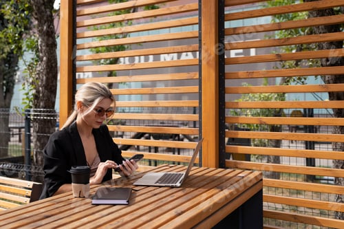 Preview: woman working on a laptop in the city in a cafe