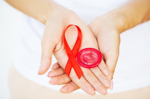 Preview: Woman holds a condom and a red ribbon, warning against AIDS