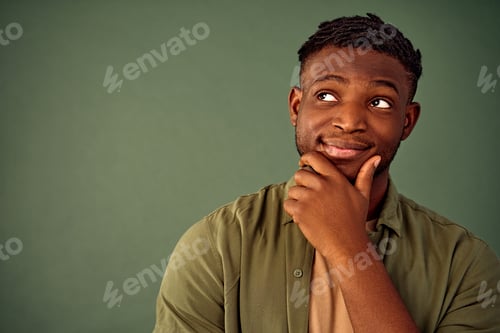 Preview: Lost in thoughts. Close up portrait of african american man standing over green background with hand