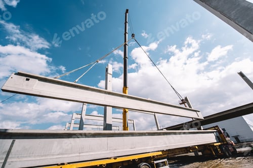 Preview: Industrial heavy duty crane lifting precast cement beams and pillars on construction site