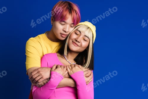 Preview: Asian couple with multicolored hair hugging while smiling together