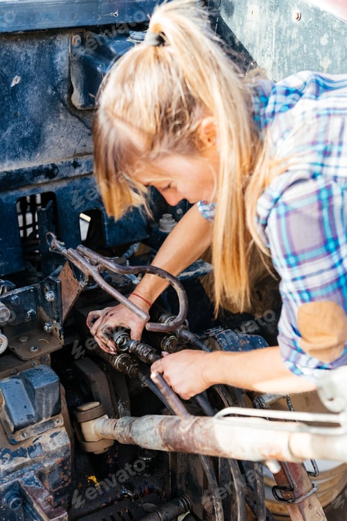 Preview: Woman Repairing Heavy Machinery Equipment on a Farm