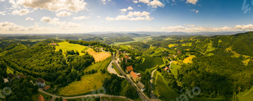 Preview: Aerial panorama of of green hills and vineyards with mountains in background. Austria vineyards