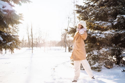 Preview: Happy woman walking in the snowy winter day outdoor. Winter fashion, holidays, rest, travel concept.