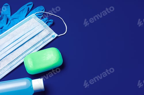 Preview: Coronavirus prevention. Facial mask, gloves, soap and sanitizer on blue background