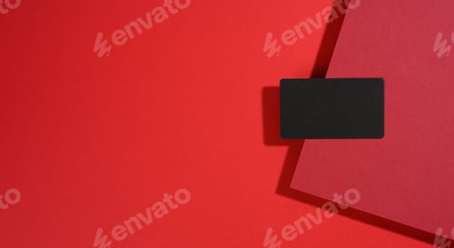 Preview: Blank black rectangular business card lies on a modern red background with red sheets