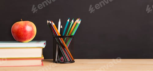 Preview: School books, apple and pencils over chalkboard background