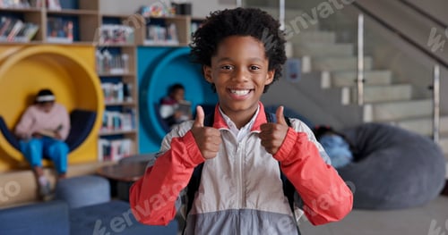 Preview: Portrait, boy and smile with backpack, thumbs up and happy for education in library and joy for lea