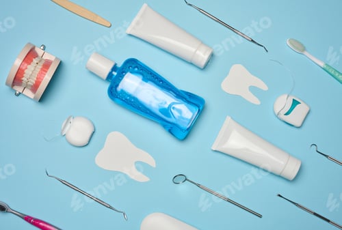 Preview: Mouthwash, toothpaste tube, dental floss and medical mirror on a blue background, oral hygiene.