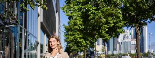 Preview: Vertical shot of successful business woman, team leader in suit, holding digital tablet, walking on