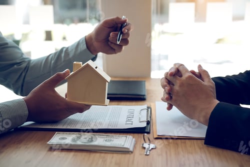 Preview: Business people home sales broker is using a pen pointing to the house model