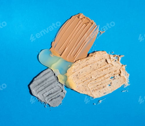 Visualização: Amostras aproximadas de produtos cosméticos em fundo azul. Tendência de autocuidado