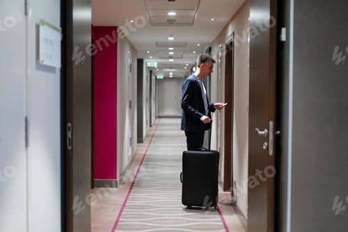 Preview: A man with a suitcase opens the door of a hotel room a businessman on trip travel concept