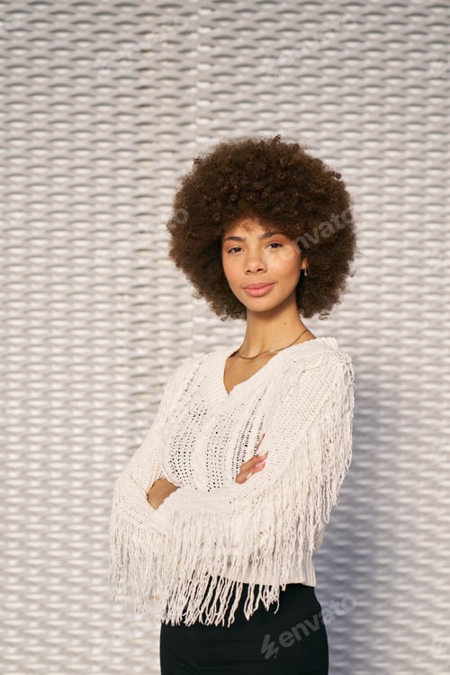 Preview: Confident young woman with afro hairstyle posing with folded arms