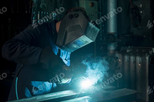 Preview: Welder at work in a dark workshop