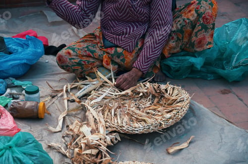 Preview: Midsection of woman weaving wicker basket in Kathmandu