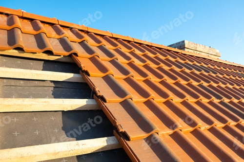 Preview: Overlapping rows of yellow ceramic roofing tiles mounted on wooden boards covering residential