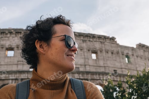 Preview: Portrait of a woman wearing sunglasses in profile against the background of the Roman colosseum