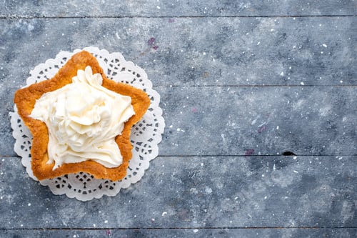 Preview: top view delicious baked cake star shaped with white yummy cream inside on the light desk cake bake