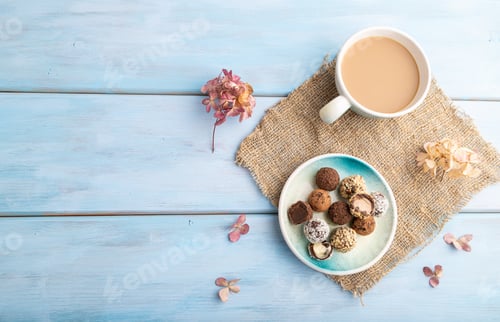 Preview: Chocolate truffle candies with cup of coffee on a blue wooden background. top view, copy space.