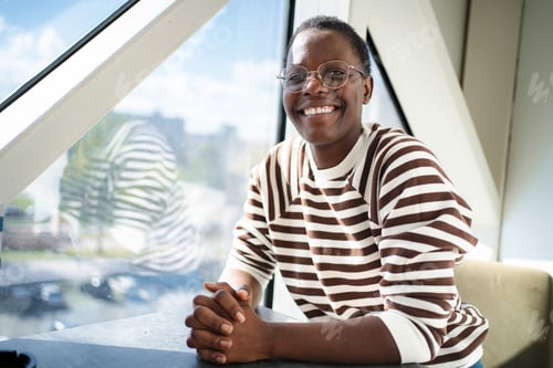 Preview: Smiling African American woman wearing glasses looking at camera