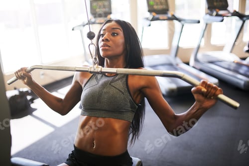 Preview: fit african american woman working out and stretching in gym