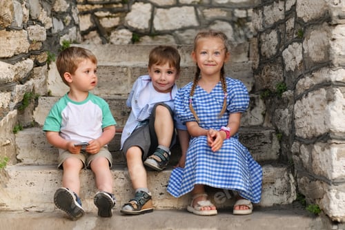 Preview: Cheerful children sit on the stairs