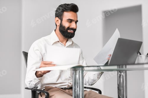 Preview: Cheerful indian professional reading documents with a smile