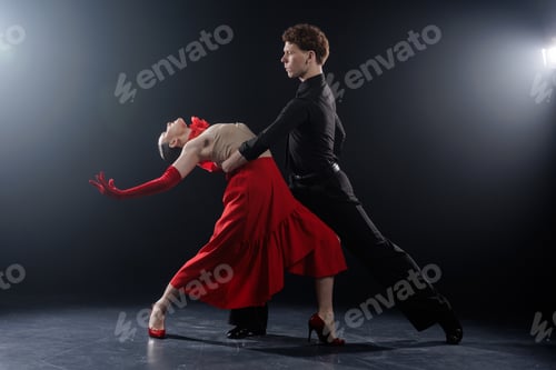 Preview: Dance Couple Performing Dramatic Dip Pose in Studio with Controlled Lighting