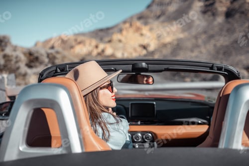 Preview: Woman traveling by cabriolet car on the desert road