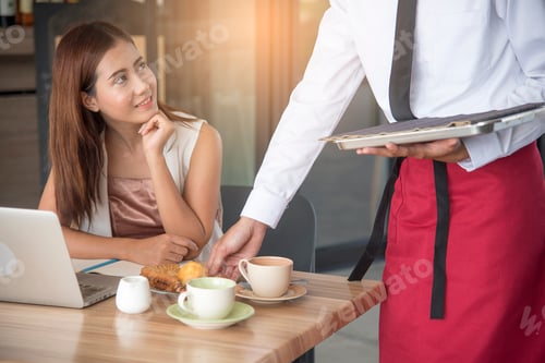 Visualização: Linda mulher de negócios sorrindo olhando para o garçom bonito enquanto serve comida.