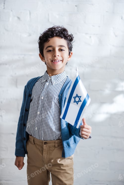 Preview: smiling and cute jewish boy holding flag of israel