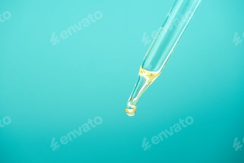 Preview: Drop yellow serum for skin care on blue background