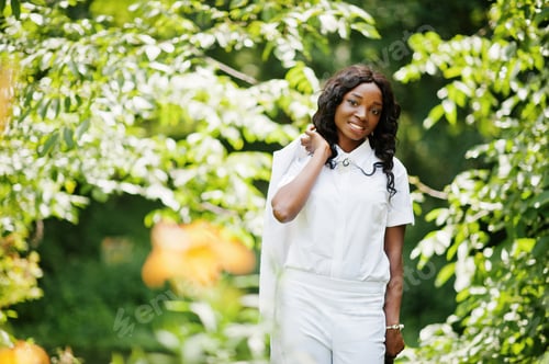 Preview: Stylish black african american girl holding jacket on her shoulder at green park